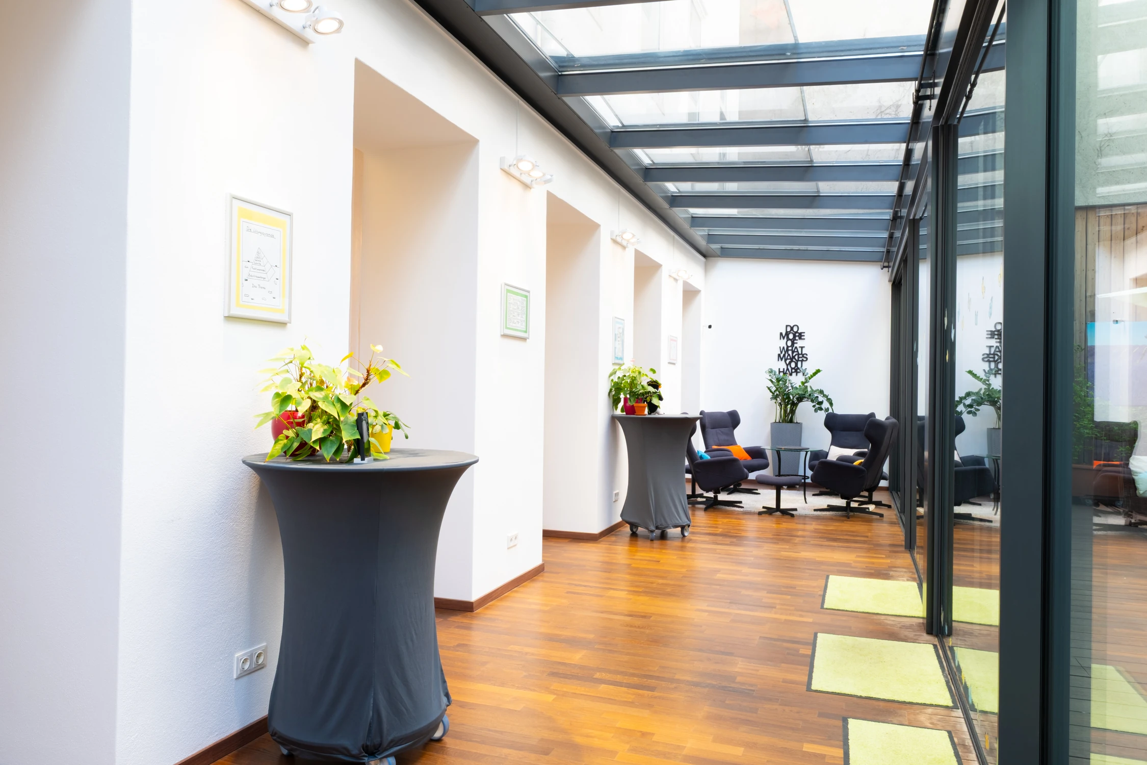 Wintergarten bei SeminarFREUNDE mit Stehtischen, Pflanzen, gemütlicher Lounge-Ecke und Glasdach
